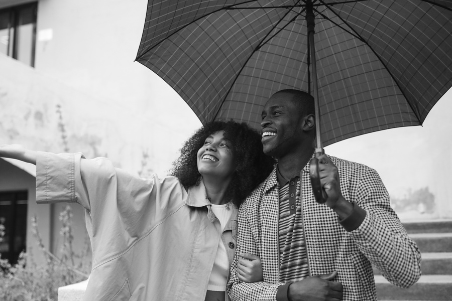 Black and White Photography of Couple Under Umbrella